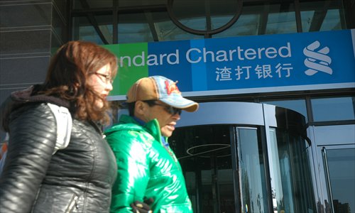 Two women pass by a Standard Chartered bank branch in Zhengzhou, Central China's Henan Province.  Photo: CFP