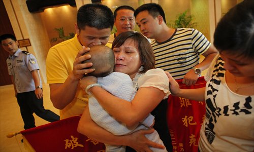 Parents of a baby boy cry Sunday in Guangzhou, Guangdong Province, after the police rescued the baby from a human trafficking ring that abducted the baby on September 12 and sold him in faraway Henan Province. Four suspects were arrested and another remains at large. Photo: CFP