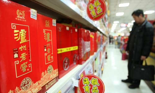A customer looks at Luzhou Laojiao liquor in a supermarket in Shanghai. Photo: IC
