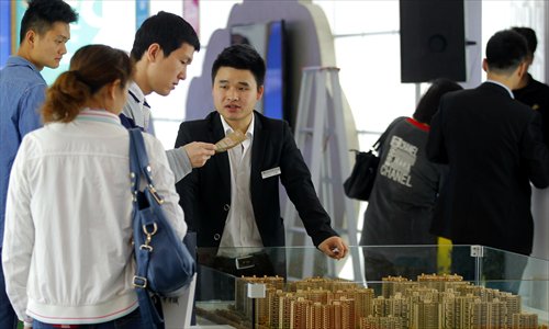 A real estate agent (right) tells visitors about a residential development Saturday at the Shanghai Real Estate Expo, which ran until Saturday at the Shanghai Exhibition Center. Shanghai's property market remained quiet during the Labor Day holiday as many buyers held a wait and see attitude, according to a report on Shanghai Television Station Saturday. Photo: Yang Hui/GT
