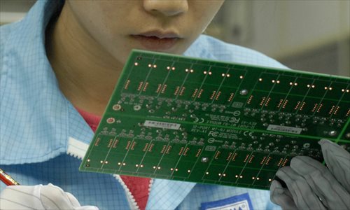 A worker checks semiconductors in an electronics factory in Dongguan, South China's Guangdong Province. Photo: IC
