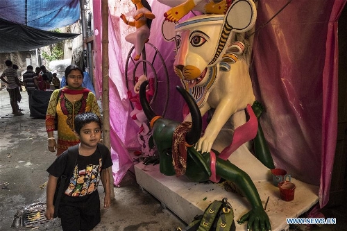 Indian commuters walk through a studio where clay idols of Goddess Durga are ready for the upcoming Durga Puja festival at Kumartuly in Kolkata, India, on Sept. 28, 2016. Durga Puja is one of the largest Hindu festivals that involves worship of Goddess Durga who symbolizes power and the triumph of good over evil in Hindu mythology. (Xinhua/Tumpa Mondal) 