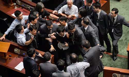 Newly elected lawmaker Baggio Leung (C) is restrained by security after attempting to deliver his Legislative Council (LegCo) oath in Hong Kong on Wednesday. Photo: AFP