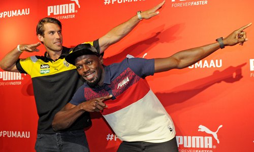 Jamaican sprinter and Olympic champion Usain Bolt (right) poses in his signature move with Australian rules footballer Alex Rance during an event at a store in Melbourne, Victoria, Australia on Tuesday. Photo: IC