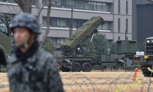 A Japan Self-Defense Forces soldier stands guard near a PAC-3 surface-to-air missile launcher unit (center), used to engage incoming ballistic missile threats, in position at the Defense Ministry in Tokyo on Monday. Three of the four missiles launched by North Korea on Monday landed in Japanese-controlled waters, Prime Minister Shinzo Abe said. Photo: AFP
