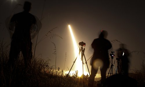 Photographers take pictures of a streak of light trailing off into the night sky as the US military test fires an unarmed intercontinental ballistic missile  at Vandenberg Air Force Base, some 209 kilometers northwest of Los Angeles, California early on Wednesday. Photo: AFP