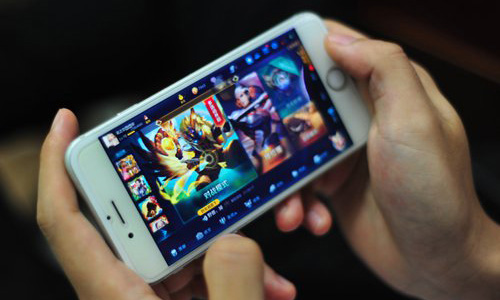 A person plays the game Honor of Kings on his smartphone in Shenzhen, South China's Guangdong Province on Wednesday. Photo: IC