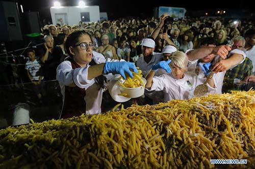 Volunteers serve potato fries during the event on Naxos island, Greece, July 15, 2017. It took more than 1,500 kg of raw Naxos potatoes, 22 huge cauldrons, the hard work of 40 volunteers to break the Guinness World Record for cooking the heaviest batch of fries. The electronic scale that weighed the fried potatoes read 554 kg, which is 100 kg more than the previous world record set in 2014 in Eagles, Idaho, in the United States. The event was held during the 8th Naxos Potato Festival, one of the most popular gastronomic festivals of the Aegean Sea. (Xinhua/Lefteris Partsalis)
