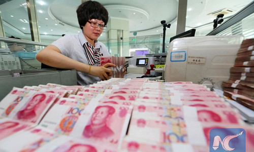 A worker counts Chinese currency Renminbi (RMB) at a bank in Lianyungang, east China's Jiangsu Province, Aug. 11, 2015. (Xinhua/Si Wei)