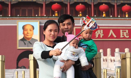 A family deploys a selfie stick at Tiananmen Square in Beijing on Friday. China announced the implementation of its comprehensive two-child policy in October 2015, allowing all couples to have two children starting 2016. Nearly 60 percent of the 7.4 million babies born in the first five months of 2017 were a family's second or even third child. Photo: IC