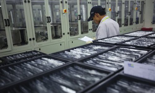 An employee of Nanchang CENAT New Energy Co checks a production line of lithium batteries on September 7, 2017. The company supplies the product for new-energy vehicles made by Jiangling Motors Corp based in Nanchang, capital of East China's Jiangxi Province. Photo: VCG
