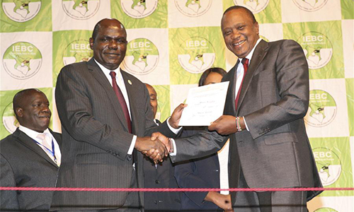 Kenyan President Uhuru Kenyatta (R, front) receives the certificate as the winner of the repeat presidential election from Independent Electoral and Boundary Commission (IEBC) chairman Wafula Chabukati in Nairobi, capital of Kenya, Oct. 30, 2017. Kenya's Uhuru Kenyatta won the repeat presidential elections boycotted by opposition, garnering 98.2 percent of the vote cast, Kenya's electoral body said on Monday.(Xinhua/Charles Onyango)