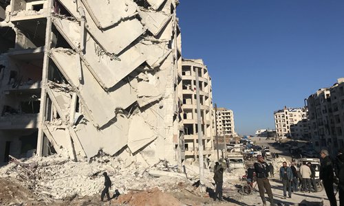 People look at  damage in the aftermath of an explosion that killed at least 23 people and injured tens more at a base for Asian jihadists in a rebel-held area of the northwestern Syrian city of Idlib on Monday. Photo: AFP
