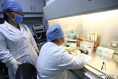 Staff members check influenza virus at Capital Pediatrics Research Institute in Beijing, capital of China, Jan. 11, 2018. China's health authority has urged strengthened monitoring and treatment in face of the current influenza outbreak. The National Health and Family Planning Commission (NHFPC) in a circular asked medical organs at all levels to reserve enough antiviral medicines, and allocate medical resources and equipment such as respirators and monitors for timely treatment of severe cases. The commission also demanded close monitoring of the mutation of flu virus strains, and suggested schools have daily check-ups for students. (Xinhua/Zhang Yuwei) 
