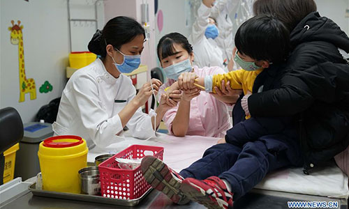 A child receives treatment at Beijing Children's Hospital in Beijing, capital of China, Jan. 10, 2018. China's health authority has urged strengthened monitoring and treatment in face of the current influenza outbreak. The National Health and Family Planning Commission (NHFPC) in a circular asked medical organs at all levels to reserve enough antiviral medicines, and allocate medical resources and equipment such as respirators and monitors for timely treatment of severe cases. The commission also demanded close monitoring of the mutation of flu virus strains, and suggested schools have daily check-ups for students. (Xinhua/Zhang Yuwei) 