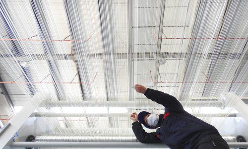 A worker at Zhongfu Shenying Carbon Fiber Co checks the production line of carbon fiber T1000 in Lianyungang, East China's Jiangsu Province on Tuesday. The recent self-developed production line of the 100-ton T1000 marks the high-performance carbon fiber reaching a new level in China. At present, the carbon fiber company has mastered the T700 and T800 with kiloton-level technology as well as the M30 and M35 with hundred-ton-level technology. Photo: IC