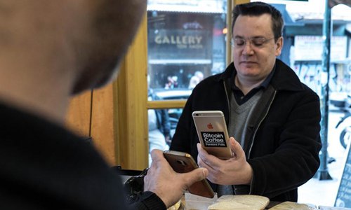 A customer uses his mobile phone to pay with bitcoin at a coffee shop in central Athens, Greece, February 25, 2018. Greece's bitcoin community has been growing in recent years, fueled by capital controls imposed on the traditional banking system since the summer of 2015, said users and investors to Xinhua, even as local authorities warn of the risks of cryptocurrencies. (Xinhua/Lefteris Partsalis).