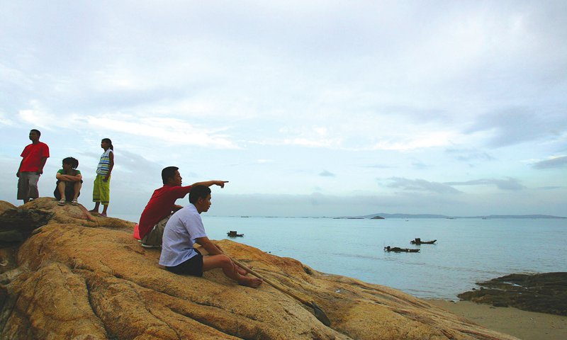 Mainlanders point to the Kinmen Islands from a beach in Xiamen,Fujian Province.Photo; VCG