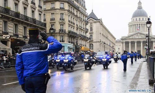 Gendarmes salute the hearse of the hero officer Arnaud Beltrame outside the Pantheon in Paris, France on March 28, 2018. Amid rains, a ceremony was held on Wednesday at the military museum Les Invalides in Paris to pay tribute to the hero officer Arnaud Beltrame, who died of serious wounds he got when he voluntarily swapped himself for a female hostage during an attack on a supermarket in Trebes, southern France, on Friday. Photo: Xinhua/Chen Yichen