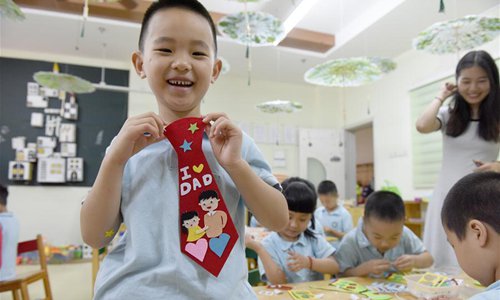 A child displays a tie which he made for his father as a gift for this year's Father's Day at Zhonghuancheng kidergarten in Hefei City, east China's Anhui Province, June 14, 2018. (Xinhua/Guo Chen)