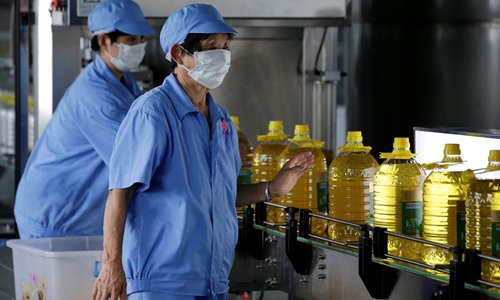 Workers check bottles of soybean oil made from imported US soybeans at a production plant in Qufu, East China's Shandong Province on July 4. Photo: VCG
