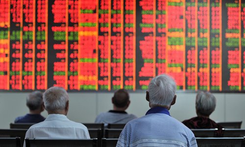 Investors check the A-share market at a securities brokerage in Jinhua, East China's Zhejiang Province in July. Photo: VCG
