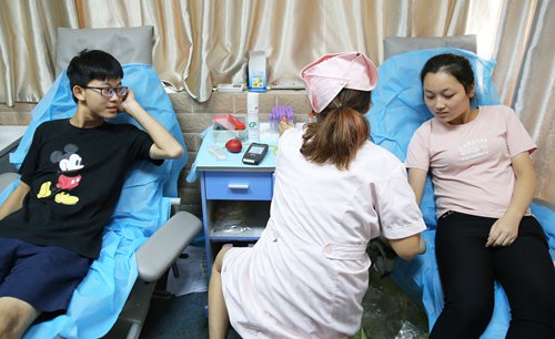 Two students of Hengyang-based University of South China on Thursday donate blood at a blood donation station at Xiangzheng district, Hengyang, Central China's Hunan Province. Wednesday's car rampage in the city killed 11 people and injured 44 others. Dozens of universities donated blood as of Thursday afternoon. Photo: IC