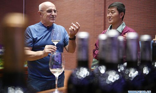 A French wine maker (L) tastes wine with a local worker at a chateau in Yongning County, northwest China's Ningxia Hui Autonomous Region, Sept. 13, 2018. The wine industry in Ningxia started in 1980s. Its wine grape cultivation has reached 38,000 hectares so far. The annual wine output of Ningxia is nearly 100,000 tonnes. The brewing industry also provided job opportunities to local people. (Xinhua/Wang Peng)
