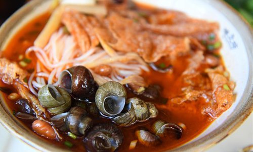 A bowl of river snail rice noodles is served at a restaurant in Liuzhou, south China's Guangxi Zhuang Autonomous Region, Sept. 20, 2018. The harvest season of river snails in Liuzhou has begun. In recent years, the promotion of river snail rice noodles benefits over 4,500 impoverished households in Liuzhou. (Xinhua/Li Hanchi)