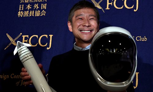 Yusaku Maezawa, SpaceX BFR's first private passenger, poses with a miniature rocket and space helmet prior to the start of a press conference at the Foreign Correspondents' Club of Japan in Tokyo on Tuesday. Photo: AFP