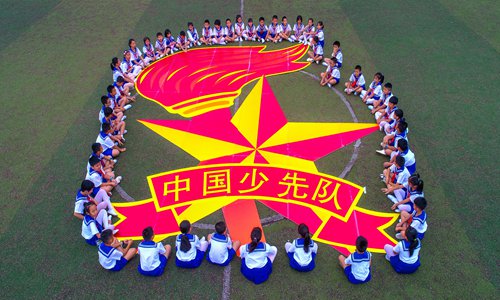 A group of primary school students in Haikou, South China's Hainan Province on Friday sit in a circle during an activity to mark the 69th anniversary of the founding of Chinese Young Pioneers. The local chapter of the Chinese Young Pioneers welcomed 633 students into its ranks on the day. Photo: IC