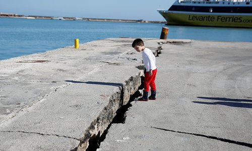 A child looks at the damaged pier in the Greek port of Zakynthos, following an earthquake near the island on Friday. A powerful 6.8-magnitude undersea earthquake struck early Friday off the Ionian Sea island of Zante, causing structural damage but no injuries, officials said. Photo: VCG