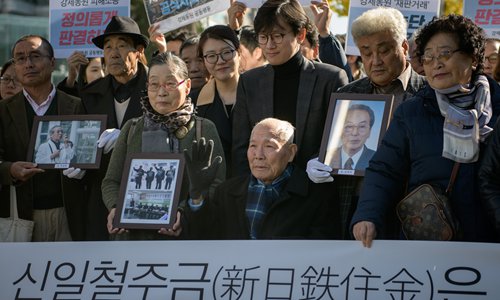 Lee Chun-sik (center), a victim of forced labor by Japan during its colonial rule of the Korean Peninsula from 1910 to 1945, is surrounded by supporters and relatives outside the supreme court in Seoul on Tuesday. Photo: AFP