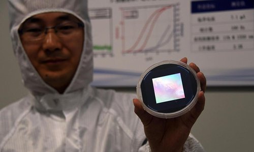 A researcher shows a device produced with the lithography equipment on November 29. Photo: VCG
