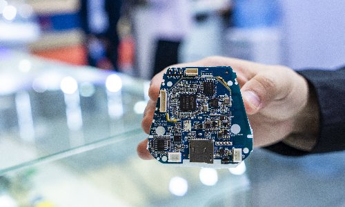 An employee showcases a semiconductor integrated circuit at an industry expo on October 31. Photo: VCG