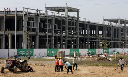 Construction workers labor at the OPPO factory that is under construction in Greater Noida, India, on October 22. Photo: VCG