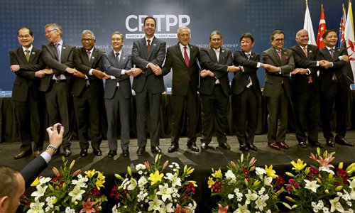 Representatives from CPTPP member countries hold hands after the signing ceremony of the CPTPP in Chile on March 8, 2018. Photo: IC