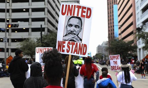 People hold posters in the 41st annual Original MLK Jr. Parade in Houston, the United States, on Jan. 21, 2019. Various activities are held on the third Monday of January each year throughout the United States to honor Martin Luther King Jr., who was assassinated on April 4, 1968 at the age of 39. (Xinhua/Yi-Chin Lee)


