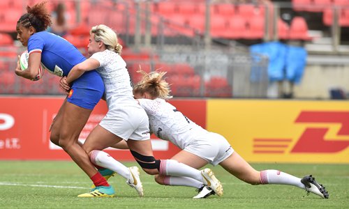France's Anne-Cecile Ciofani (left) heads to score a try as England's Claire Allan (right) and Emma Uren try to tackle her in the women's Rugby Sevens tournament in Sydney, Australia on Friday. Photo: AFP