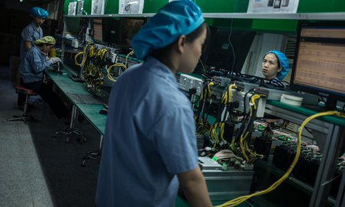 Workers conduct tests on Bitcoin miners at a Bitmain production base in Shenzhen, South China's Guangdong Province. File photo: VCG 