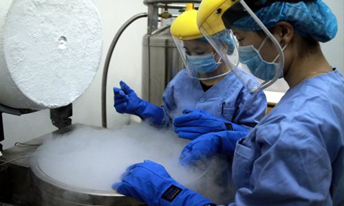 Two workers store sperm in a liquid nitrogen tank kept at below -196 C in a sperm bank in Shenyang, Liaoning Province. Photo: CFP