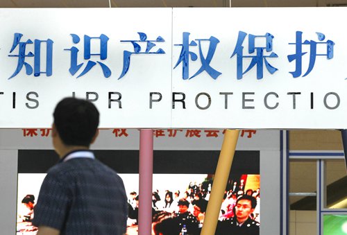 A visitor walks past a signboard on intellectual property rights protection during a trade fair in Beijing on May 29, 2016. Photo: IC