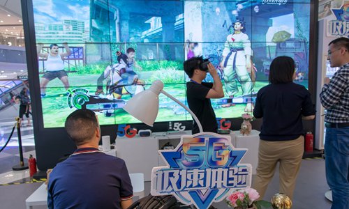 Consumers play games powered by 5G technology in a shopping mall in Shanghai on Wednesday. The applications, which are supported by China Telecom, allow local residents to experience the high speed of the 5G network and games driven by cloud computing. Photo: IC