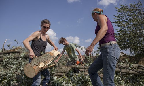 Commuinty members cut down downed trees in their yard in Beavercreek, Ohio, on Tuesday, after powerful tornadoes ripped through the US state overnight, causing widespread damage and power outages. One death has been reported so far, an 81-year-old man in Celina, Ohio, said Celina Mayor Jeffrey Hazel. Photo: AFP