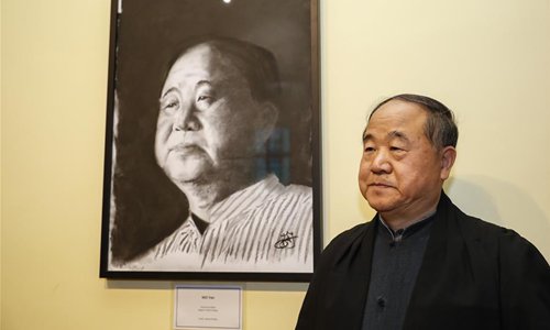 Chinese writer and Nobel laureate Mo Yan poses with a portrait of himself after the Honorary Fellowship Recognition Ceremony at University of Oxford, Britain, on June 12, 2019. Mo Yan was awarded Wednesday the Honorary Fellowship by Regent's Park College, University of Oxford, in recognition of his contribution to Chinese and world literature. The college principal Robert Ellis presented the gown and stole to Mo at the ceremony. They unveiled together a new international writing center named after Mo.(Photo: Xinhua)