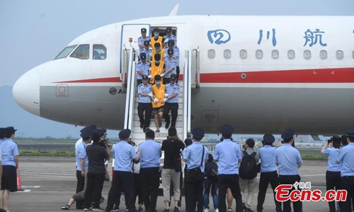 Sixty-three telecom fraud suspects, repatriated from Cambodia, arrive at an airport in southwest China's Chongqing Municipality, June 26, 2019, under the escort of police. The suspects are part of a group of 73 people caught in a joint China-Cambodia police operation earlier this month. The suspects allegedly made phone calls to people on the Chinese mainland cheating victims out of money in dozens of cases involving more 5 million yuan ($730,000). (Photo: China News Service)