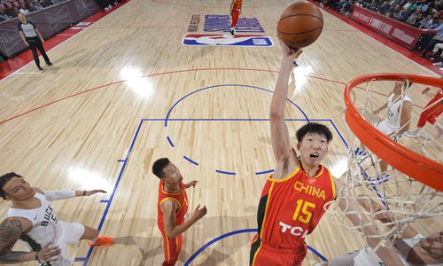 China's center Zhou Qi dunks against the Milwaukee Bucks in an NBA Summer League game on Wednesday at the Cox Pavilion in Las Vegas, Nevada. China lost the match 84-67 while Zhou scored 14 points. Photo: VCG