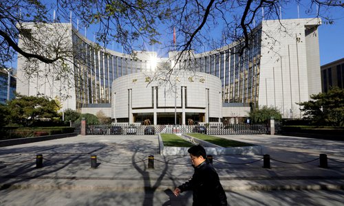A man walks past the headquarters of the People's Bank of China, the central bank, in Beijing File photo: VCG
