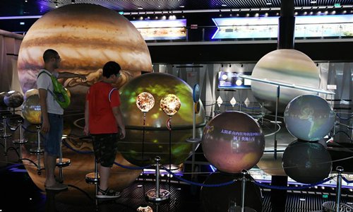 Visitors watch the solar system models at the astronomical museum in Pingtang during summer vacation in southwest China's Guizhou Province, July 24, 2019. (Xinhua/Yang Wenbin) 