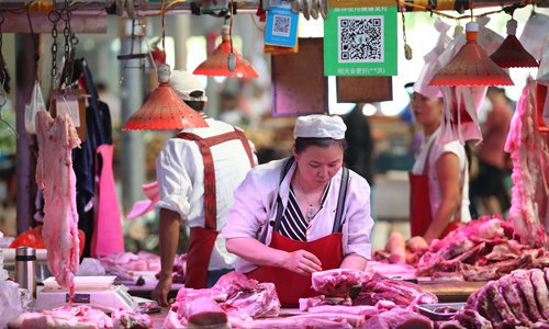 Chinese vendors sell pork and other meat products at their stalls in a market in Kunming, capital of Southwest China's Yunnan Province in June. Photo: IC